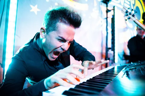 The Gloves keyboardist leaning over the keys during a lively performance
