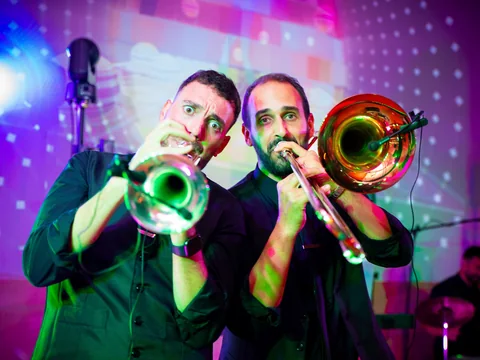 The Gloves trumpet and trombone players facing the camera