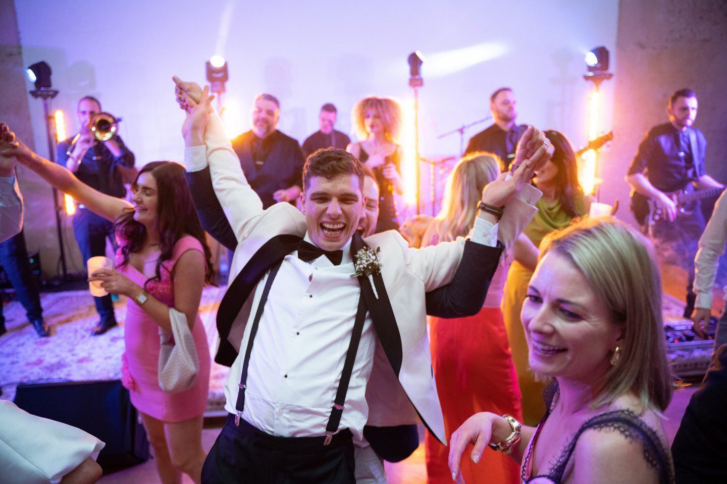 Wedding guests dancing and celebrating with a live band in Italy