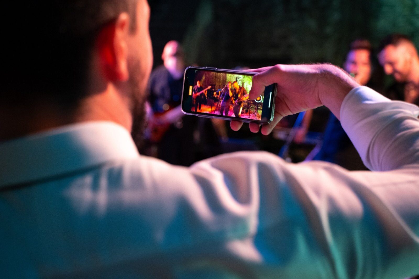 Ospite di un matrimonio che riprende la band dal vivo con uno smartphone durante un’esibizione ad alta energia