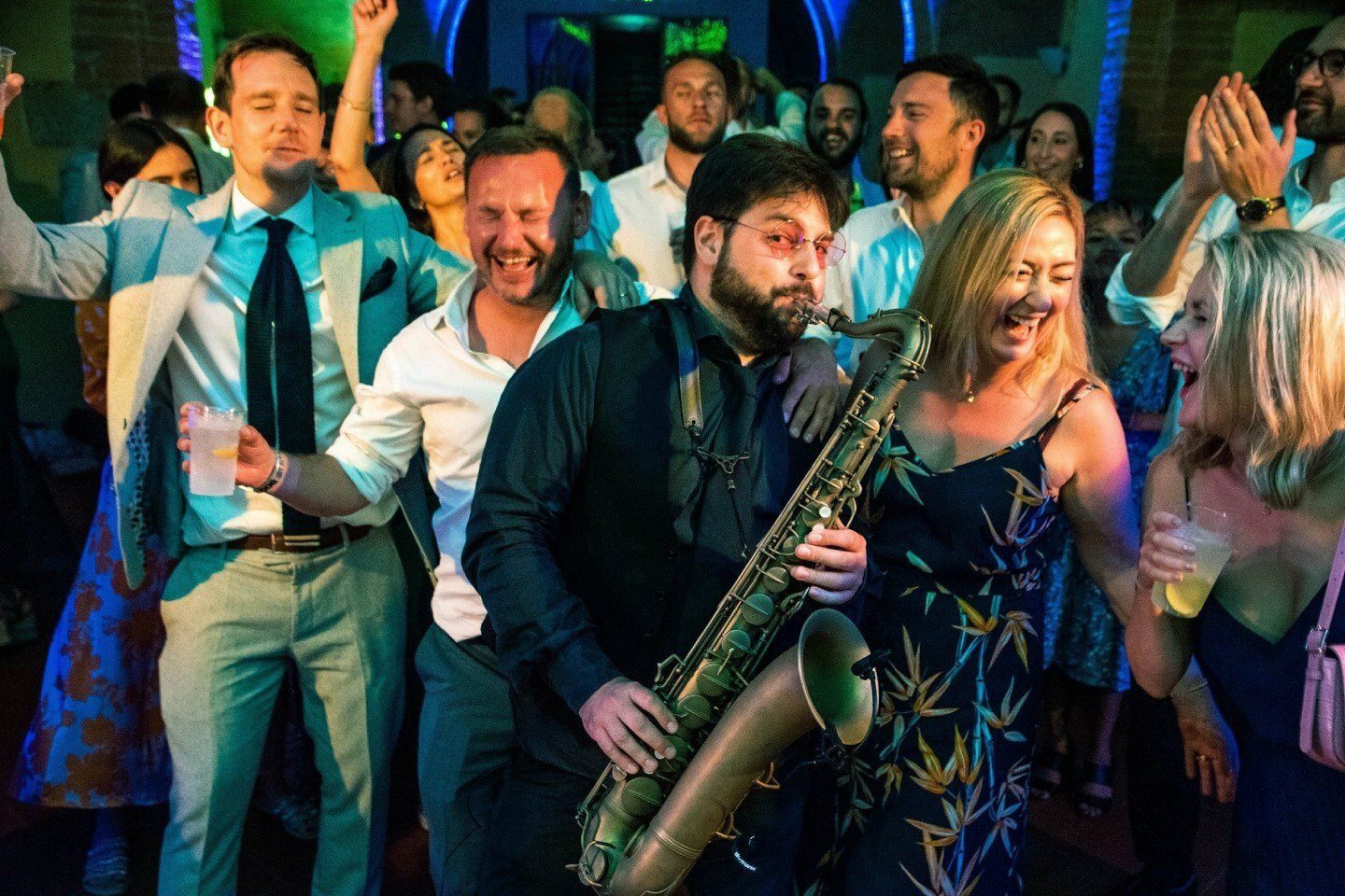 Wedding DJ performing with a live saxophonist during a reception