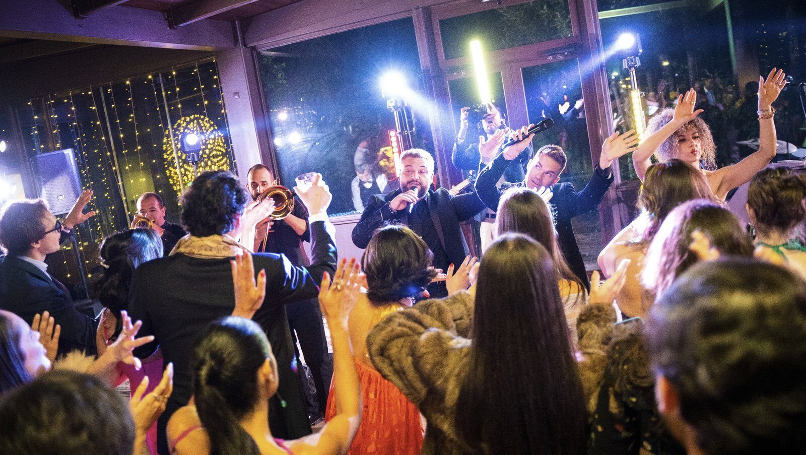 Cantante che interagisce con gli ospiti mentre la band suona dal vivo a un matrimonio in Italia